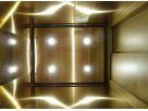 Ceiling view of gold-coloured Oro HL stainless steel lift cabin with integrated spotlights