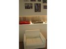 White armchair in front of illuminated Champagne SB stainless steel wall niche