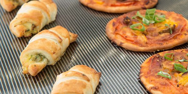 Warm snacks and small pizzas on ribbed stainless steel warming plate