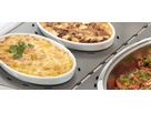 Baking dishes with hot meals on ribbed stainless steel warming plate in display unit