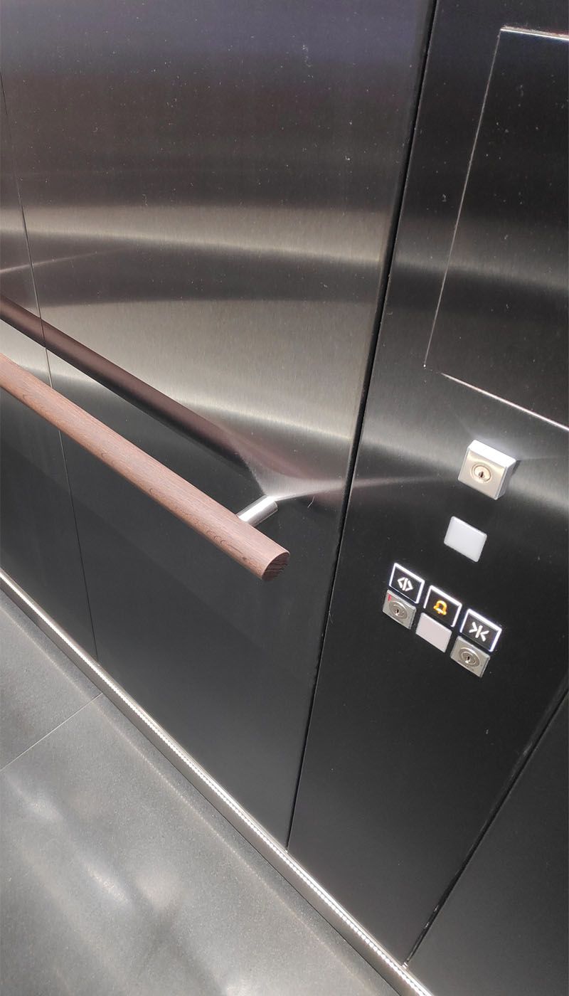 Innenansicht des Multimedia-Aufzugs mit Handlauf und Bedienpanel aus Edelstahl Grigio Satinato